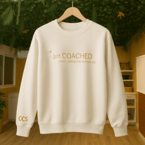 White sweatshirt with gold text on hanger.