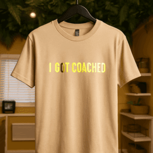 Beige t-shirt with "I Got Coached" text.