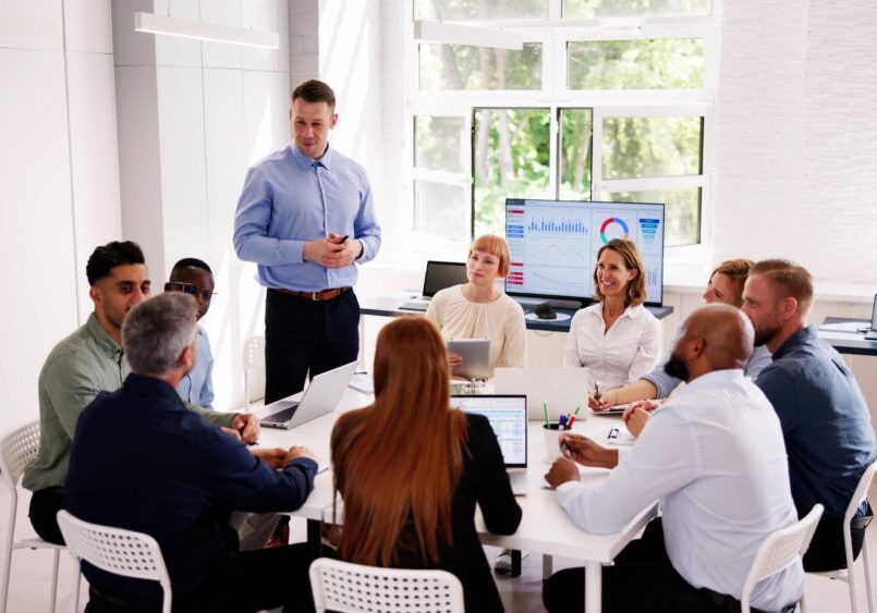 Office meeting with diverse team discussing presentation.